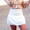falda blanca corta con borlas redondas en la parte inferior